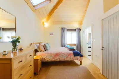 a bedroom with a bed and a dresser at Stunning Old Carthouse with seaview in Penzance