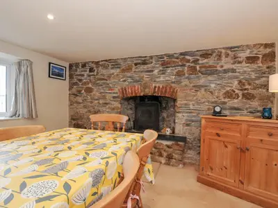 a bedroom with a bed and a stone fireplace at Rosewin Farmhouse in Wadebridge