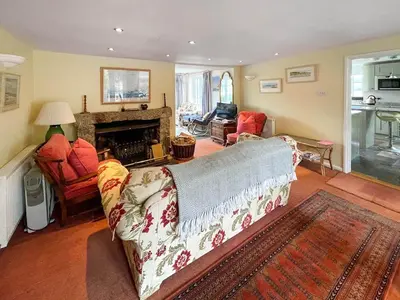 a living room with a couch and a fireplace at Point House in Saint Just in Roseland
