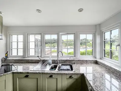 a kitchen with a sink and four windows at Point House in Saint Just in Roseland
