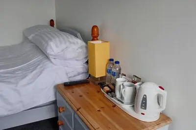 a bedroom with a bed and a wooden table with a tea maker at The Fourways Inn in Saint Minver
