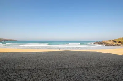 a beach with a person walking on the sand at 2 Bed in St Ives oc-bpp03 in St Ives