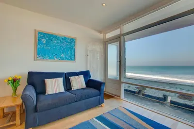 a blue couch in a living room with a view of the ocean at 2 Bed in St Ives oc-bpp03 in St Ives