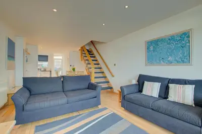 a living room with two blue couches and a staircase at 2 Bed in St Ives oc-bpp03 in St Ives