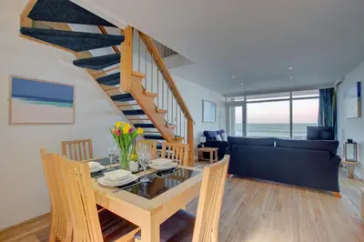 a dining room and living room with a spiral staircase at 2 Bed in St Ives oc-bpp03 in St Ives
