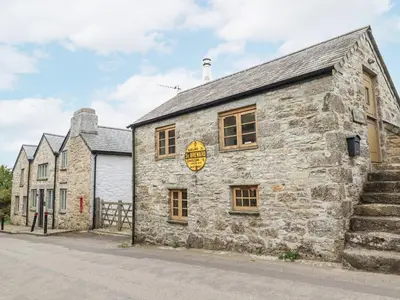 an old stone building with a sign on it at The Old Dairy in Bodmin