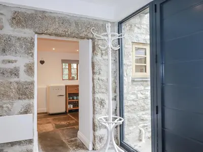 a door into a room with a stone wall at The Old Dairy in Bodmin