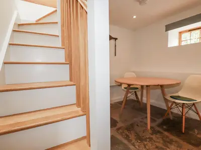 a room with a table and a staircase at The Old Dairy in Bodmin