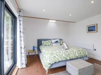 a bedroom with a bed and a window at The Old Dairy in Bodmin