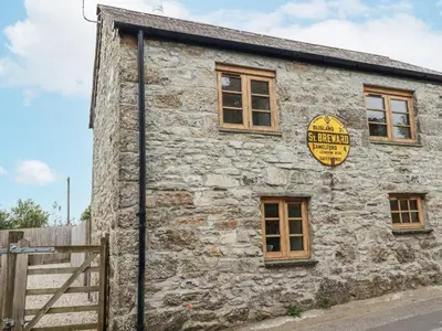 an old stone building with a sign on it at The Old Dairy in Bodmin