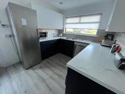 a kitchen with a stainless steel refrigerator and a window at Sleeps 9- KingBeds- FamilyFriendly- ContactlessCI in Wadebridge