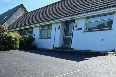 a white house with a door and a driveway at Sleeps 9- KingBeds- FamilyFriendly- ContactlessCI in Wadebridge