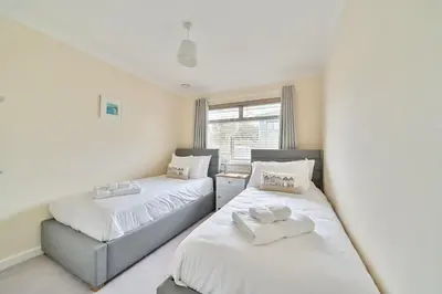 a bedroom with two beds and a window at Sleeps 9- KingBeds- FamilyFriendly- ContactlessCI in Wadebridge