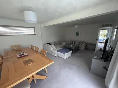 a living room with a table and a couch at Sleeps 9- KingBeds- FamilyFriendly- ContactlessCI in Wadebridge