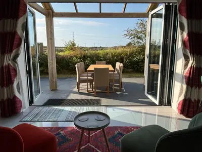 a dining room with a table and chairs on a patio at Roughtor View in Camelford
