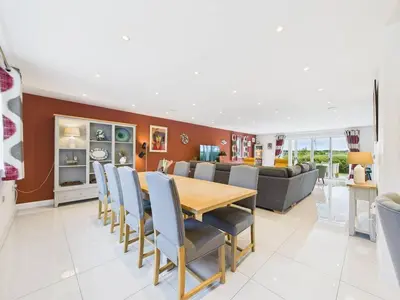 a dining room and living room with a table and chairs at Roughtor View in Camelford