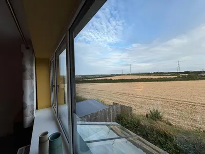 a view of a field from a window of a house at Roughtor View in Camelford