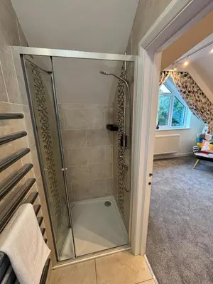 a shower with a glass door in a bathroom at Roughtor View in Camelford