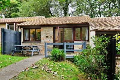 a small cottage with a blue bench in front of it at Finest Retreats - Joyful Cottage in St Ives