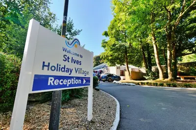 a sign for a holiday village on a street at Finest Retreats - Joyful Cottage in St Ives