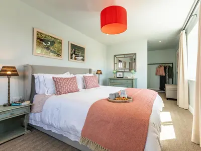 a bedroom with a large bed with a red lamp at 5 Bed in Fowey oc-93849 in Polruan