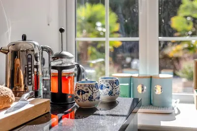 a counter with a coffee maker and cups on it at 3 Bed in Sithney oc-cpv110 in Carleen