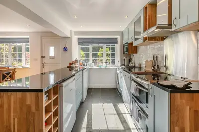 a large kitchen with white appliances and wooden cabinets at 3 Bed in Sithney oc-cpv110 in Carleen