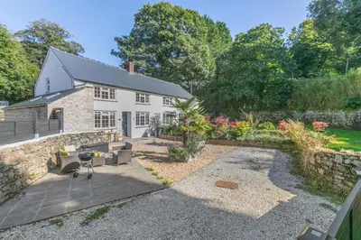 a house with a stone wall and a patio at 3 Bed in Sithney oc-cpv110 in Carleen