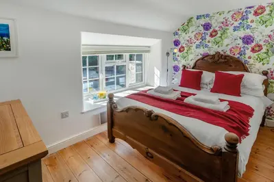a bedroom with a large bed with red pillows at 3 Bed in Sithney oc-cpv110 in Carleen