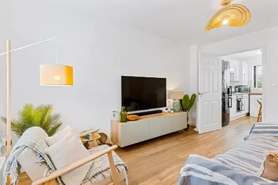 a living room with a flat screen tv on a dresser at Offshore, Coastal retreat, set in the heart of Charlestown in Charlestown