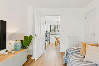 a white living room with a bed and a kitchen at Offshore, Coastal retreat, set in the heart of Charlestown in Charlestown