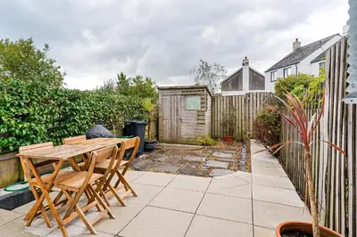 a patio with a wooden table and chairs at Offshore, Coastal retreat, set in the heart of Charlestown in Charlestown