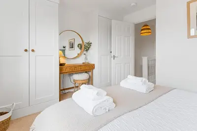 a white bedroom with a bed with towels on it at Offshore, Coastal retreat, set in the heart of Charlestown in Charlestown
