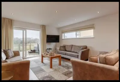 a living room with a couch and a table at Tallyn House 202 in Saint Columb Major