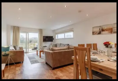 a living room with a couch and a table with chairs at Tallyn House 202 in Saint Columb Major