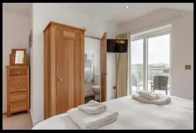 a bedroom with a bed with two towels on it at Tallyn House 202 in Saint Columb Major
