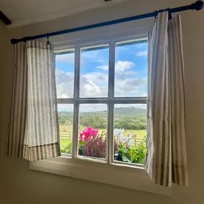 a window with a view of a field at Harpers Huts in Lanivet