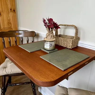 a wooden table with a vase of flowers and a basket at Harpers Huts in Lanivet