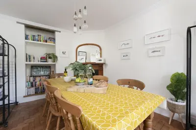 a dining room with a yellow table and chairs at Trevethen Cottage - Free Parking and WiFi - Close to Beach - Pets Welcome in Crantock