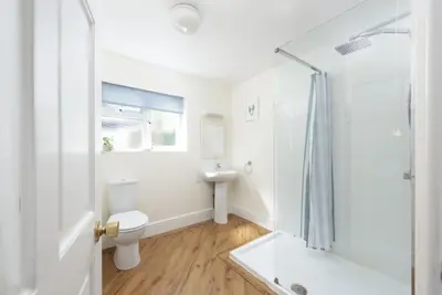 a bathroom with a toilet and a sink and a shower at Trevethen Cottage - Free Parking and WiFi - Close to Beach - Pets Welcome in Crantock