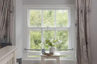 a window with a vase on a table in a room at Trevethen Cottage - Free Parking and WiFi - Close to Beach - Pets Welcome in Crantock