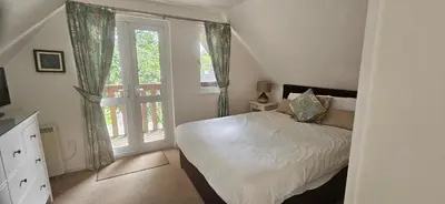 a bedroom with a bed and a large window at Family and dog-friendly holiday home - 134 Hengar Manor in Saint Tudy