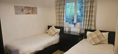 two beds in a room with a window at Family and dog-friendly holiday home - 134 Hengar Manor in Saint Tudy