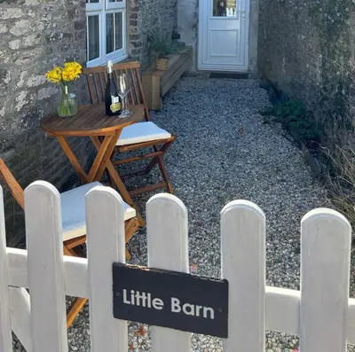a white fence with a little barn sign on it at Cute Cornish Cottage in Saint Germans