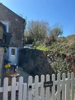 a white picket fence in front of a house at Cute Cornish Cottage in Saint Germans