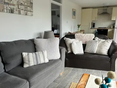 a living room with a couch and pillows at The Beach Hut in Perranporth