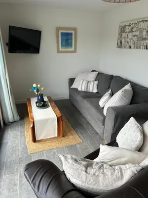 a living room with a couch and a table at The Beach Hut in Perranporth