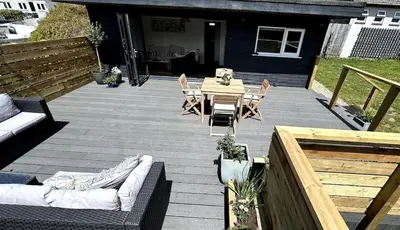 a patio with a table and a couch and chairs at The Beach Hut in Perranporth
