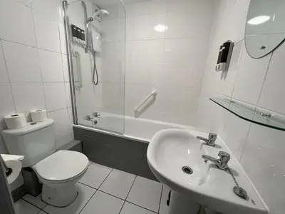 a bathroom with a sink and a toilet and a shower at Hollowell House Holiday Apartment in Boscastle