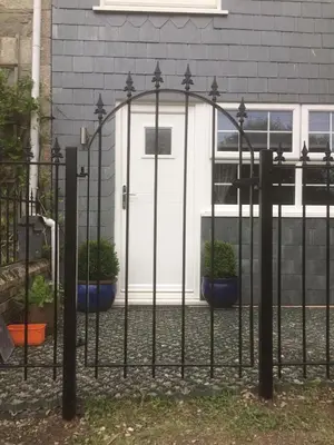 a black fence with potted plants in front of a garage at Coach House Studio, quiet, rural, pet friendly, Probus in Probus